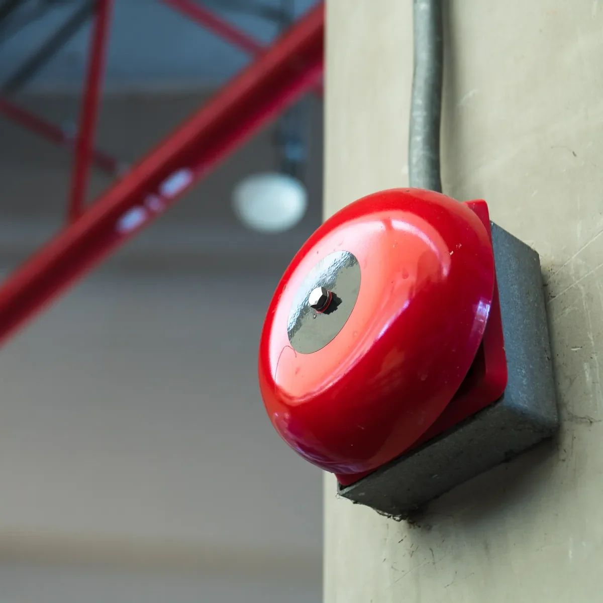 Sonnerie d’alarme incendie rouge fixée au mur d’un bâtiment industriel