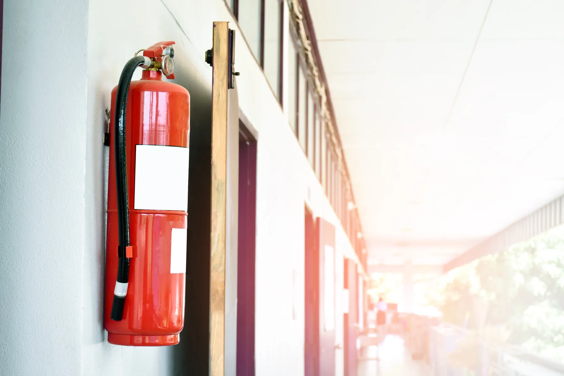 Extincteur fixé au mur de la coursive d’un établissement